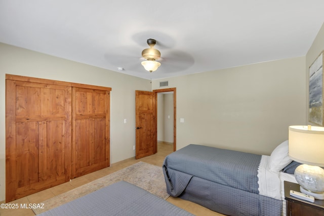 bedroom with light tile patterned floors, a ceiling fan, and visible vents