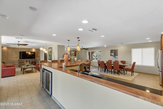 kitchen featuring beverage cooler, open floor plan, light tile patterned floors, and visible vents
