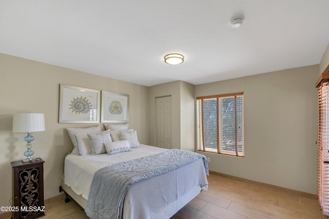 bedroom featuring baseboards and a closet