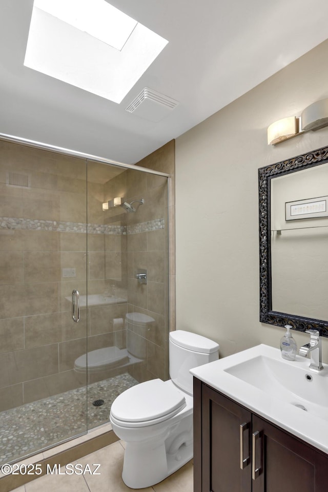 full bathroom with vanity, toilet, a skylight, visible vents, and a stall shower