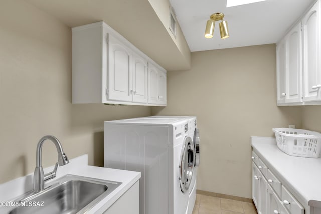 laundry area with independent washer and dryer, cabinet space, a sink, baseboards, and light tile patterned flooring