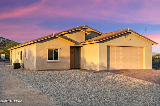 3000 S Smokin Pistol Way, Tucson, AZ 85713 - view of front facade with decorative driveway, an attached garage, stucco siding, a tiled roof, and central air condition unit