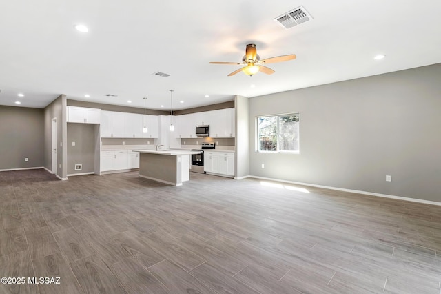 3000 S Smokin Pistol Way, Tucson, AZ 85713 - kitchen with appliances with stainless steel finishes, open floor plan, a ceiling fan, an island with sink, and recessed lighting