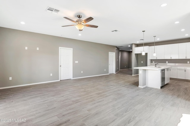 3000 S Smokin Pistol Way, Tucson, AZ 85713 - kitchen with stainless steel dishwasher, a sink, open floor plan, light countertops, and ceiling fan