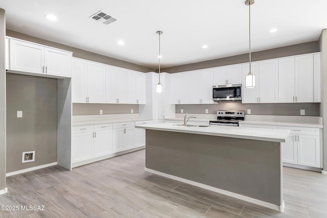 3000 S Smokin Pistol Way, Tucson, AZ 85713 - kitchen with stainless steel appliances, a sink, light wood-type flooring, white cabinets, and light countertops
