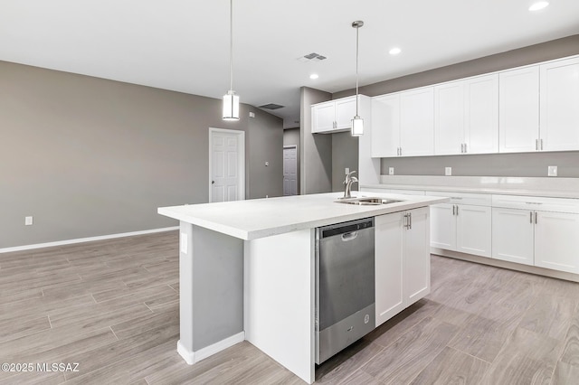 3000 S Smokin Pistol Way, Tucson, AZ 85713 - kitchen with stainless steel dishwasher, a sink, an island with sink, light countertops, and light wood-style flooring
