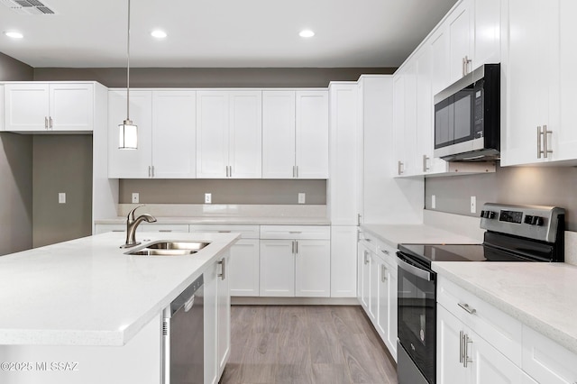 3000 S Smokin Pistol Way, Tucson, AZ 85713 - kitchen with appliances with stainless steel finishes, a sink, white cabinets, light wood finished floors, and recessed lighting