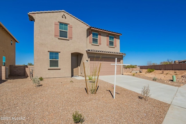 mediterranean / spanish house with stucco siding, a tiled roof, fence, a garage, and concrete driveway