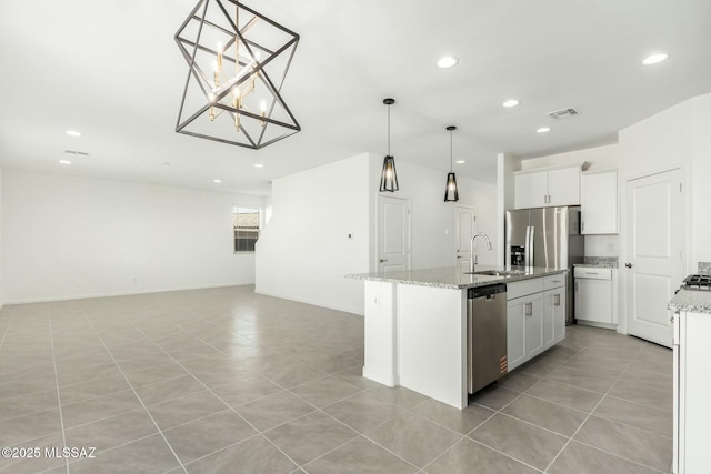kitchen with recessed lighting, a sink, stainless steel appliances, light tile patterned floors, and an island with sink