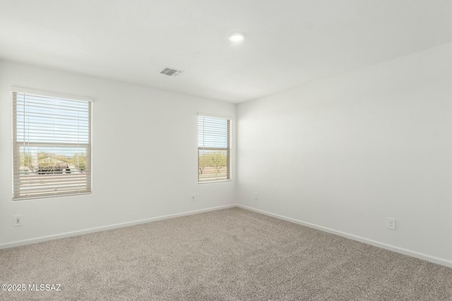 empty room with baseboards, visible vents, carpet, and recessed lighting