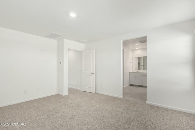 interior space featuring baseboards, visible vents, light colored carpet, and recessed lighting