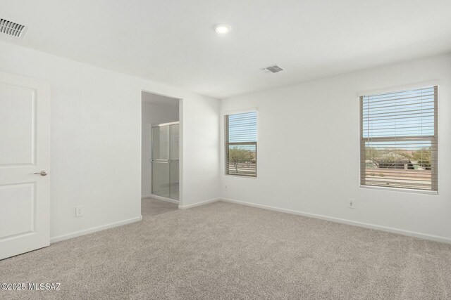 unfurnished bedroom featuring light colored carpet, visible vents, recessed lighting, and baseboards