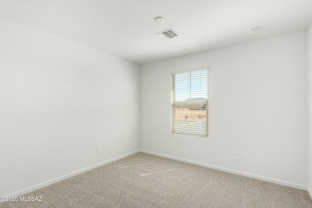 empty room featuring light colored carpet, visible vents, and baseboards