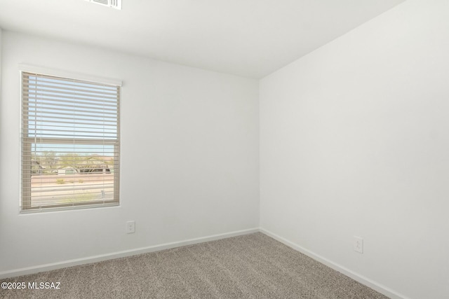 spare room featuring baseboards, visible vents, a wealth of natural light, and carpet flooring