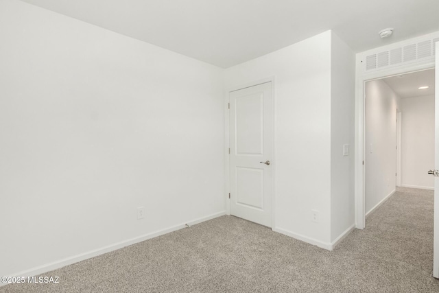 unfurnished room with baseboards and light carpet
