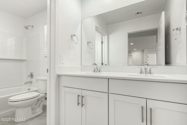 bathroom with double vanity, visible vents, toilet, and a sink