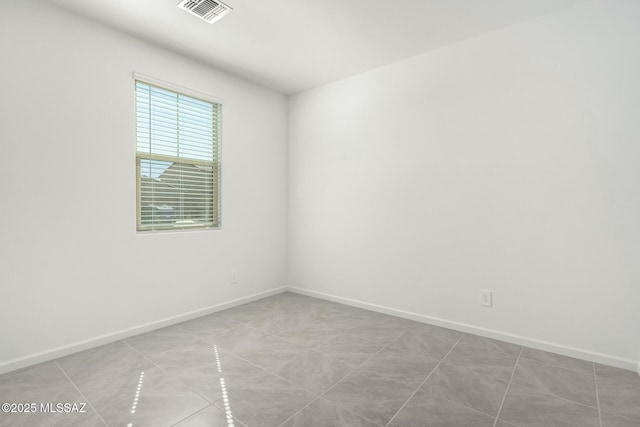 spare room featuring visible vents and baseboards