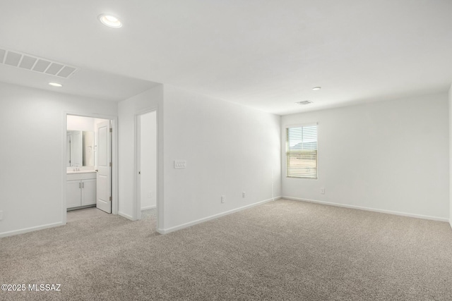 spare room featuring baseboards, visible vents, light carpet, and recessed lighting