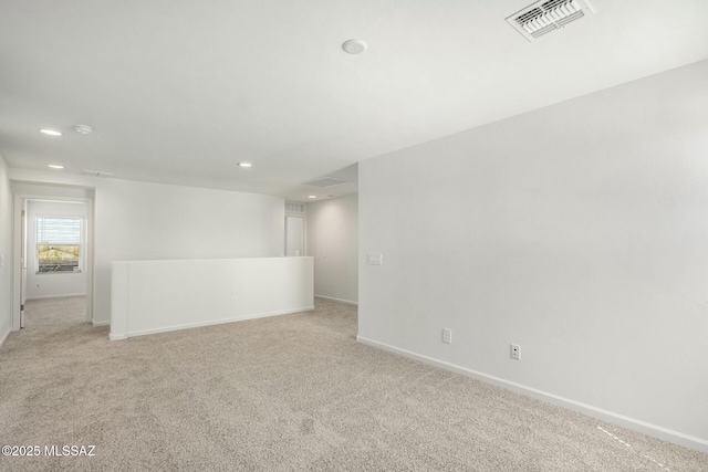 unfurnished room with baseboards, visible vents, light colored carpet, and recessed lighting