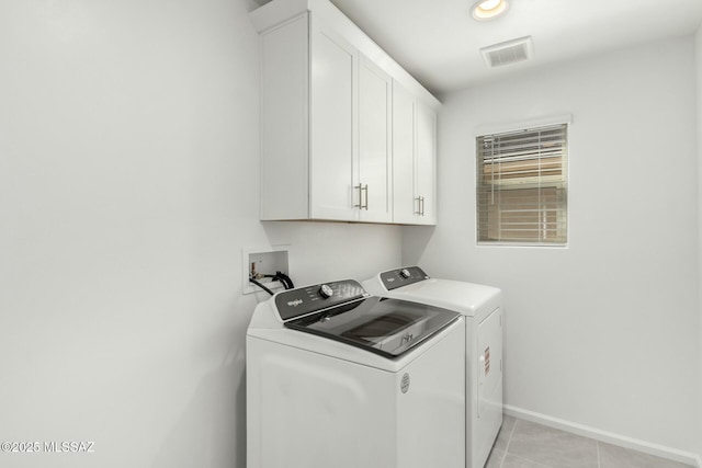laundry room with light tile patterned floors, cabinet space, washing machine and dryer, baseboards, and visible vents