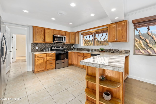 kitchen with appliances with stainless steel finishes, open shelves, a peninsula, recessed lighting, and baseboards