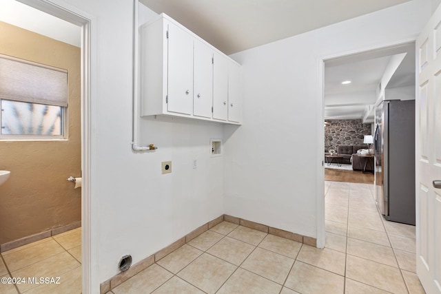clothes washing area featuring hookup for a washing machine, electric dryer hookup, light tile patterned flooring, and baseboards