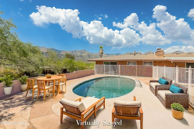 view of pool with a mountain view, a patio, outdoor lounge area, and fence