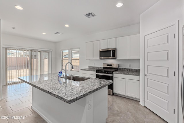 kitchen featuring appliances with stainless steel finishes, visible vents, light stone counters, and a sink