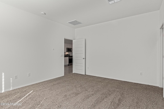 carpeted empty room featuring visible vents and baseboards