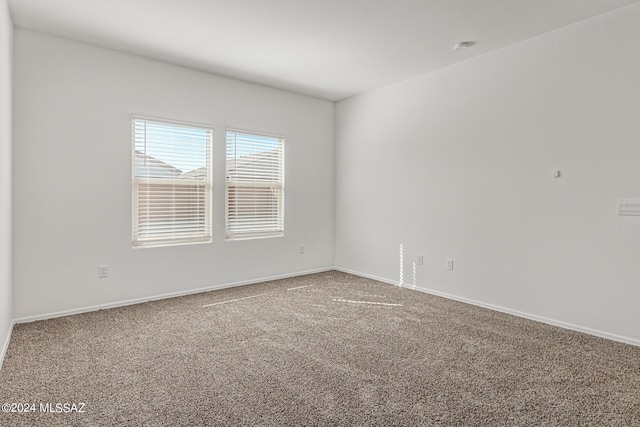 carpeted empty room featuring baseboards