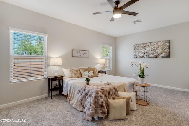 carpeted bedroom with visible vents, a ceiling fan, and baseboards
