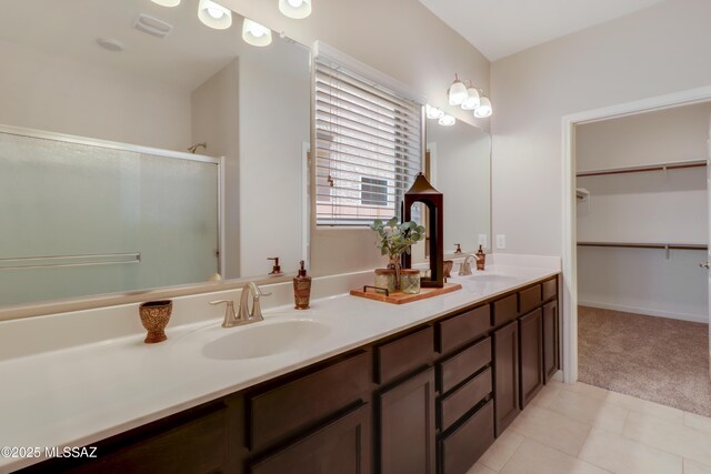full bathroom featuring tile patterned floors, a shower stall, double vanity, and a sink