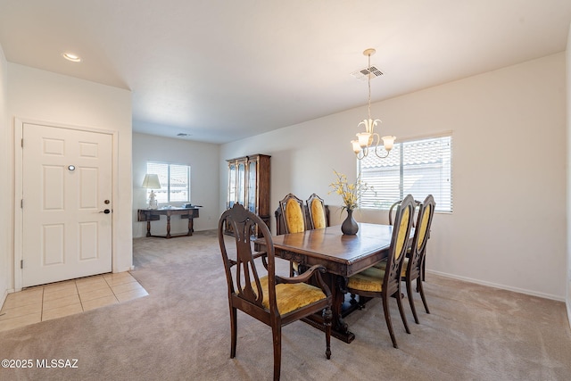 dining space with a notable chandelier, visible vents, light colored carpet, and plenty of natural light