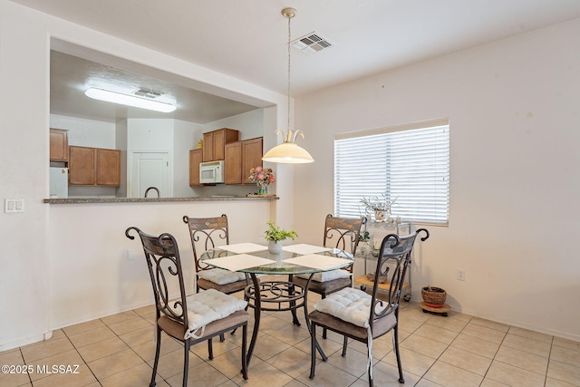 dining area featuring light tile patterned flooring and visible vents