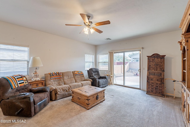 living room featuring visible vents, ceiling fan, and light carpet
