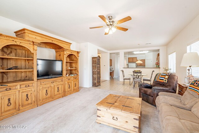 living area featuring light carpet and a ceiling fan