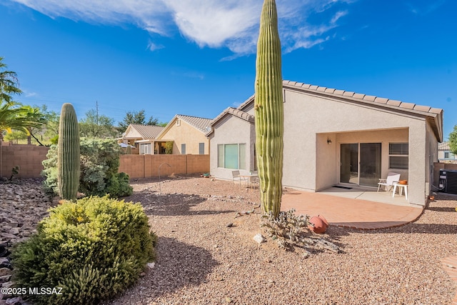 rear view of house featuring central AC unit, stucco siding, a patio area, and fence
