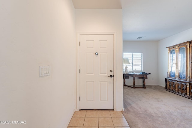 entryway with light colored carpet, visible vents, light tile patterned floors, and baseboards