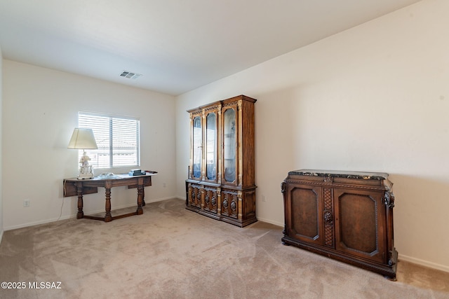 interior space featuring baseboards, visible vents, and light colored carpet