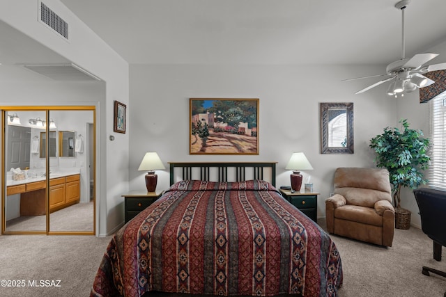 bedroom featuring light colored carpet, ensuite bath, ceiling fan, and visible vents