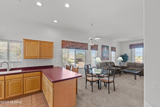 kitchen with a peninsula, a sink, ceiling fan, light carpet, and recessed lighting