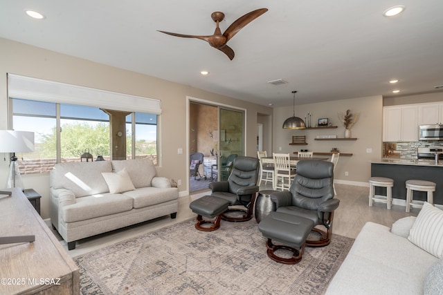 living room featuring recessed lighting, ceiling fan, and visible vents