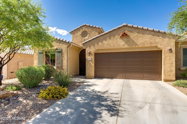 mediterranean / spanish-style home with an attached garage, stucco siding, driveway, and a tiled roof