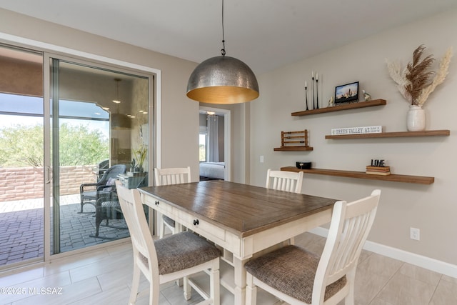 dining area featuring light tile patterned floors and baseboards