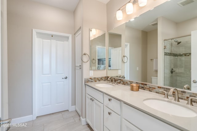 bathroom featuring visible vents, a shower stall, and a sink