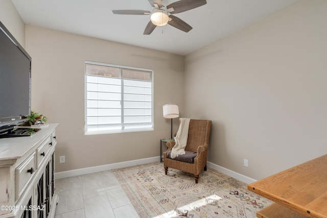 sitting room featuring ceiling fan and baseboards