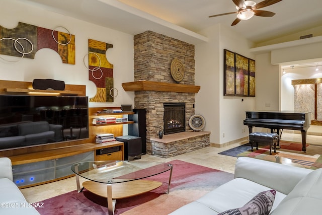 tiled living room with baseboards, a ceiling fan, a stone fireplace, and visible vents