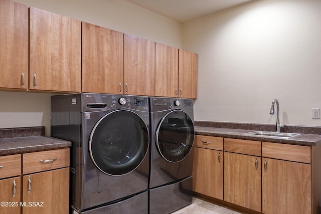 clothes washing area with cabinet space, independent washer and dryer, and a sink