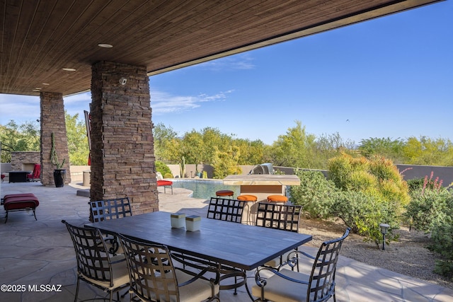 view of patio featuring an outdoor stone fireplace and outdoor dining space