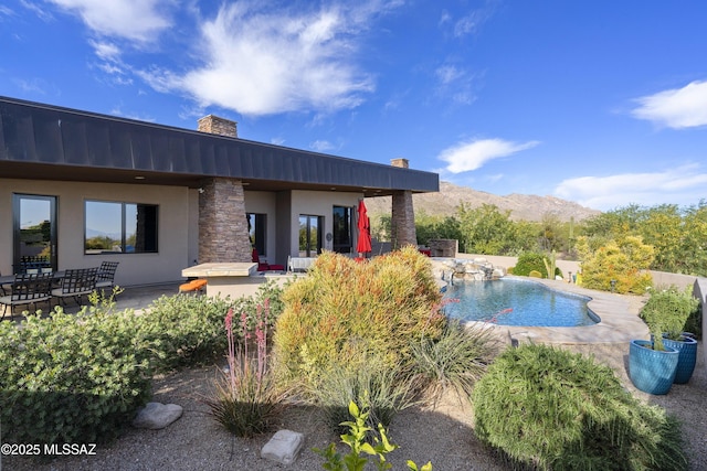 outdoor pool with a patio and a mountain view
